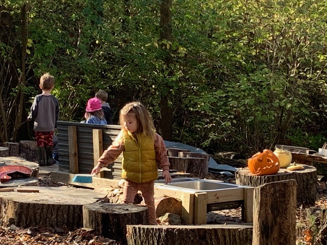 child cleaning up outside with broom